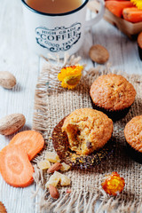 hearty and healthy breakfast, lunch, pastries, carrot cupcakes with raisins, candied fruits, nuts and green tea on a wooden background 
