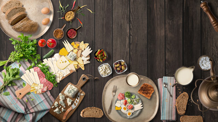 Overhead view of colorful roast vegetables, savory sauces and salt served with grilled t-bone steak...