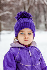 Calm little girl emotional portrait, closeup. Child walking outside. Snow winter.