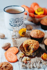 Fototapeta premium hearty and healthy breakfast, lunch, pastries, carrot cupcakes with raisins, candied fruits, nuts and green tea on a wooden background 