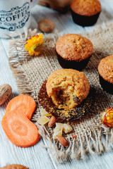 hearty and healthy breakfast, lunch, pastries, carrot cupcakes with raisins, candied fruits, nuts and green tea on a wooden background 