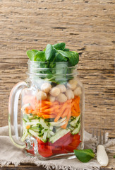 Healthy homemade Mason Jar salad with chickpeas and vegetables - cucumber, carrot, bell pepper, lettuce corn. Healthy eating, diet, detox. Selective focus