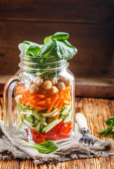 Healthy homemade Mason Jar salad with chickpeas and vegetables - cucumber, carrot, bell pepper, lettuce corn. Healthy eating, diet, detox. Selective focus