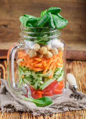 Healthy homemade Mason Jar salad with chickpeas and vegetables - cucumber, carrot, bell pepper, lettuce corn. Healthy eating, diet, detox. Selective focus