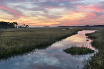 Fototapeta na wymiar Clouds Refecting in Water of Salt Marsh at Sunrise.