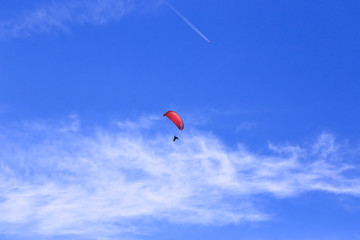 red sail parachute on blue sky with white cloud