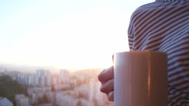couple drinking coffee with sun flare coming from window. Sunset and couple