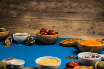 Bowls and spoons of various legumes on wooden table