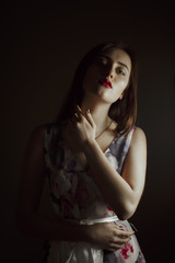 Pretty brunette woman with bright makeup posing in the dark room