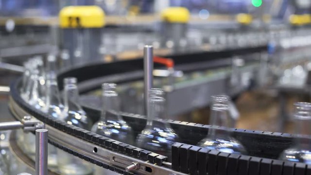 Beer bottles being sorted in a conveyer. automated industrial chain. industry and sectors of automation and robots. Technological line for bottling.
