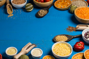 Bowls and spoons of various legumes on wooden table