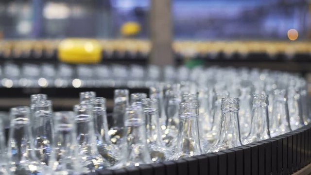 automated industrial chain of bottles for beer alcoholic and soft drinks. Technological line for bottling of beer in brewery. Closeup