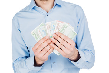portrait of young businessman holding and counts money dollar bills in hands, isolated on white background. emotion facial expression feeling. financial reward savings