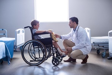 Male doctor interacting with child patient in ward