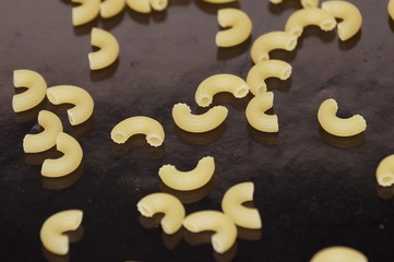 Macaroni scattered and isolated on a black background