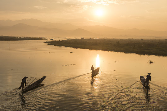 Inle lake, Nyaungshwe township, Taunggyi district, Myanmar (Burma). Three local fishermen in silhouette at sunrise.