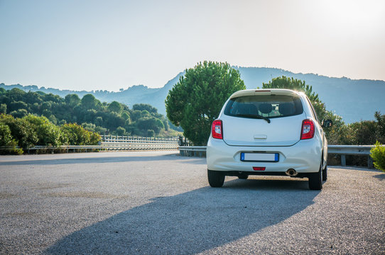 Small white car with led optics on the asphalt road highway 