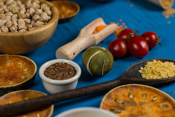 Bowls and spoons of various legumes on wooden table