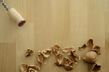Steel corkscrew, cork, and walnut on wood background