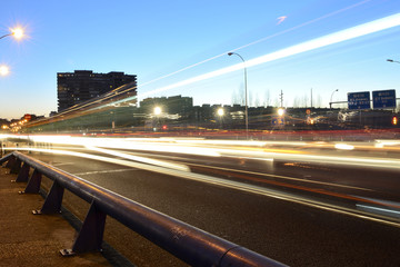 Rays of lights, car lights in a street, at dusk