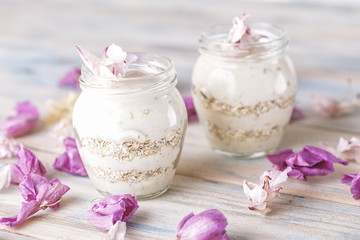Fototapeta na wymiar Delicious homemade yogurt on a table with flower petals