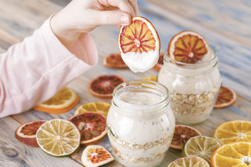 yogurt with muesli and oranges in small glass
