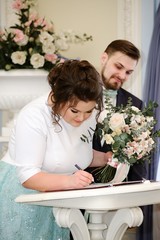 Bride and groom sign at registry office