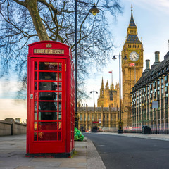 Fototapeta na wymiar London, England - The iconic british old red telephone box with the Big Ben at background in the center of London