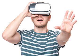 Naklejka premium Amazed man wearing virtual reality goggles watching movies or playing video games, isolated on white background. Surprised male looking in VR glasses. People experiencing 3D gadget technology.