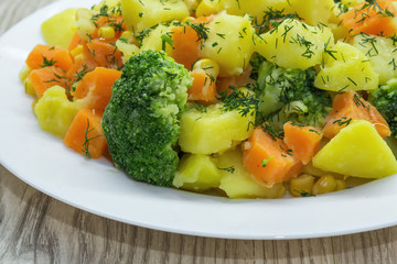 Fresh chopped dill  and Steamed Vegetables - Potatoes, Carrots, Broccoli,Corn. Healthy eating.