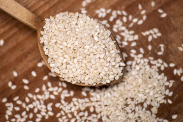 Fresh sesame seeds in a wooden spoon