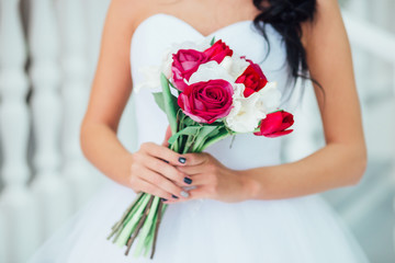 Obraz na płótnie Canvas nice wedding bouquet with red flowers in bride's hands . 