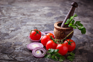 Cherry tomatoes, red onion and  mortar for spices