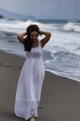 Beautiful young female walking by seaside during storm
