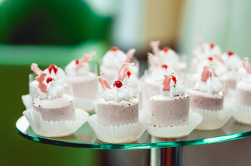 Pink craemy cakes on a stand. Close Up