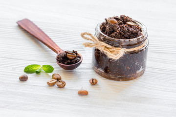 Homemade cosmetics with coffee scrub on white desk background