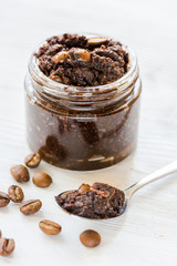 Homemade cosmetics with coffee scrub on white desk background