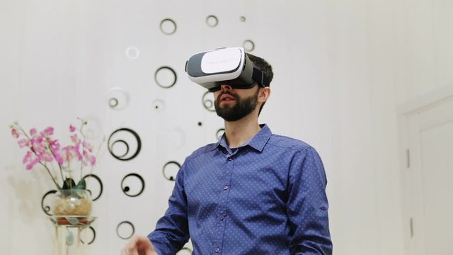 The man in the room uses a virtual reality helmet. Real Time