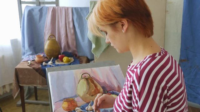A young artist in an art workshop draws a still-life from nature in watercolor.