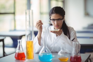 Attentive schoolgirl experimenting in laboratory