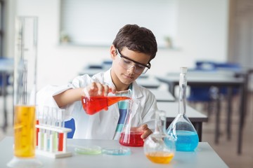 Attentive schoolboy doing a chemical experiment in laboratory