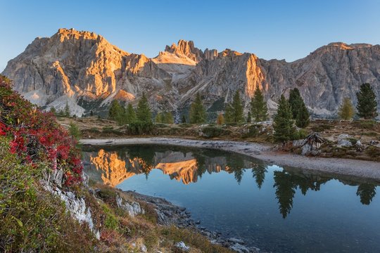 Europe, taly, Veneto, Belluno. Lake Limedes with the colors of autumn. In the background Lagazuoi and Fanis illuminated by the rays of the morning sun, Dolomites