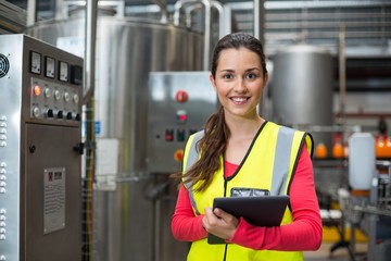 Female factory worker holding digital tablet