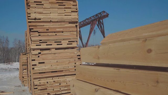 Rows of wooden bars on the street near the production area. Wooden blanks for the production of glued timber stand in the street in neat rows. Construction and the production of laminated veneer