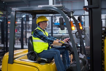 Factory worker driving forklift