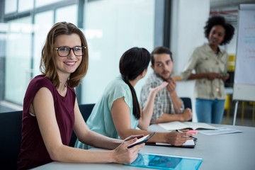 Portrait of smiling business executive using digital tablet in meeting