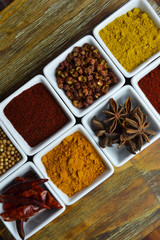 Spices in white dishes on wood table