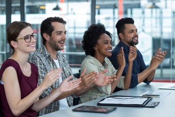 Business executives clapping in meeting at office
