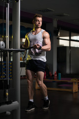 Fototapeta na wymiar Bodybuilder Exercising Biceps In Undershirt