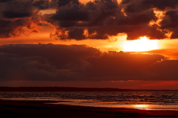Fototapeta na wymiar Orange cloudy sunset sky over the Baltic sea